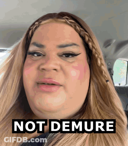 A Woman In A Car With The Words Not Demure Above Her Head GIF