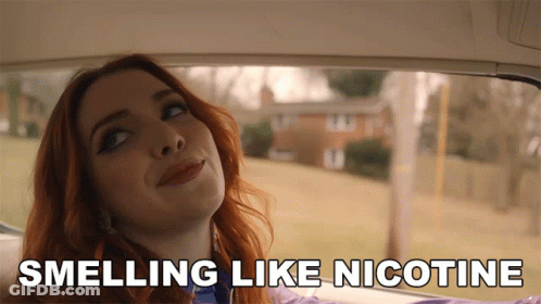 A Woman In A Car With The Words Smelling Like Nicotine GIF