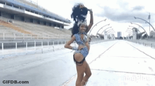 A Woman In A Carnival Costume Is Dancing On The Street GIF