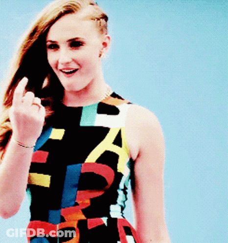 A Woman In A Colorful Dress With The Letter A On It Is Giving The Middle Finger GIF