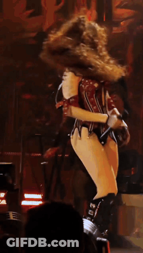 A Woman In A Corset Is Dancing On A Stage In Front Of A Keyboard GIF