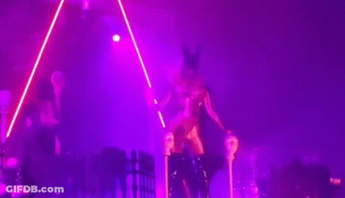 A Woman In A Costume Is Dancing On A Stage In Front Of A Crowd GIF