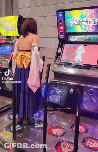 A Woman In A Costume Is Playing Dance Dance Revolution GIF