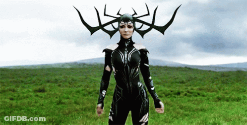 A Woman In A Costume With Horns On Her Head Is Standing In A Field . GIF