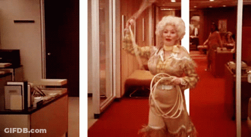 A Woman In A Cowboy Outfit Holds A Lasso GIF