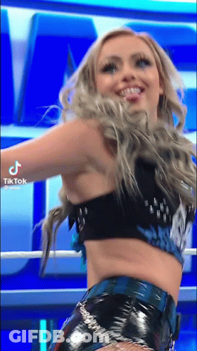 A Woman In A Crop Top And Shorts Is Dancing In A Ring . GIF