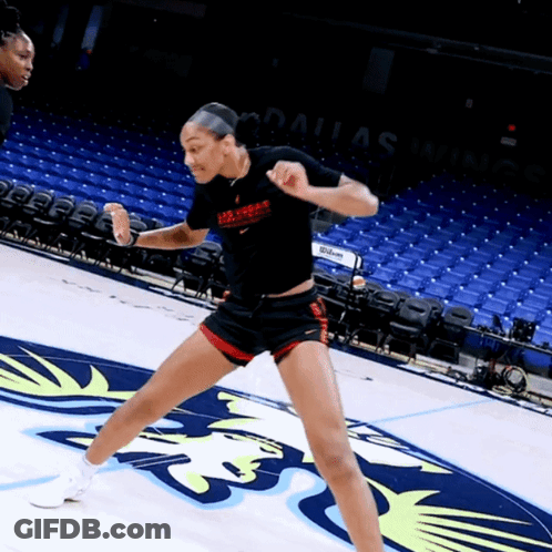A Woman In A Dallas Warriors Shirt Stands On A Court GIF