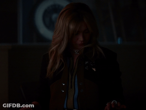 A Woman In A Dark Room With Her Hands Out GIF