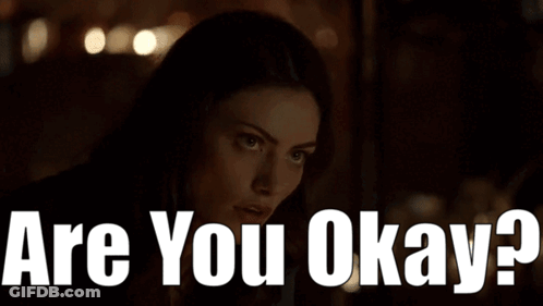 A Woman In A Dark Room With The Words " Are You Okay " On The Bottom GIF