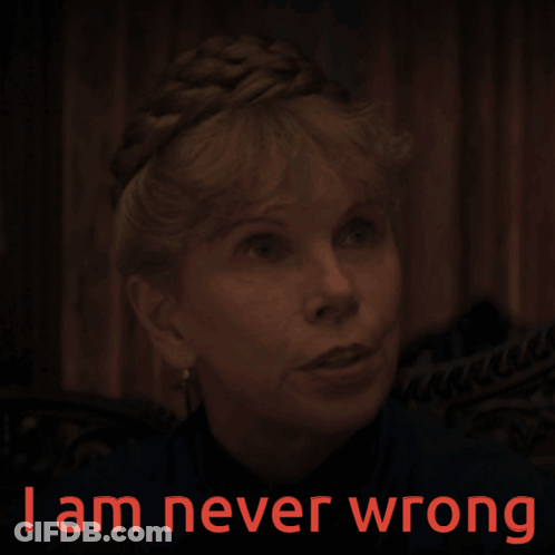 A Woman In A Dark Room With The Words " I Am Never Wrong " On The Bottom GIF