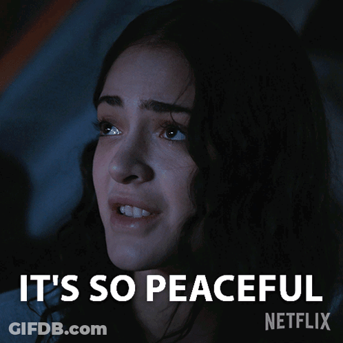 A Woman In A Dark Room With The Words It 'S So Peaceful Written Above Her GIF