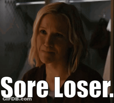 A Woman In A Dark Room With The Words Sore Loser On The Bottom GIF