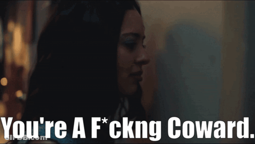 A Woman In A Dark Room With The Words You 'Re A F * Cking Coward GIF