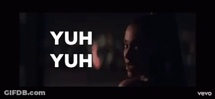 A Woman In A Dark Room With The Words Yuh Yuh On The Bottom GIF