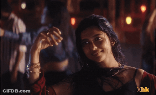 A Woman In A Dark Room With Xhk Written On The Bottom GIF