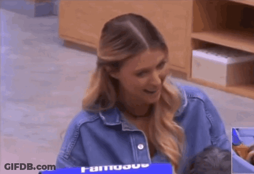 A Woman In A Denim Jacket Is Holding A Baby In A Crib . GIF