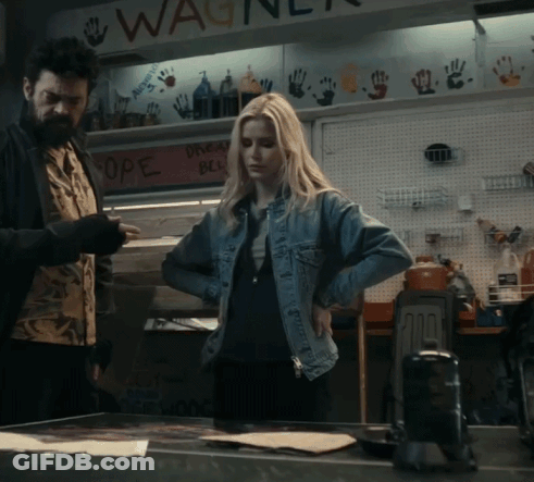 A Woman In A Denim Jacket Is Standing In Front Of A Sign That Says Wagner GIF