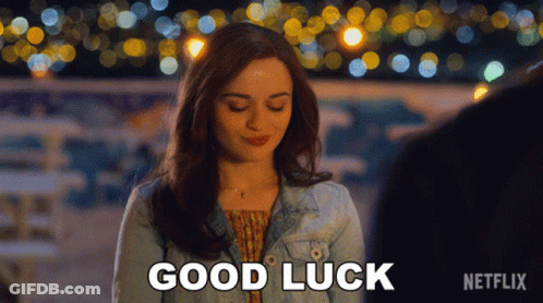 A Woman In A Denim Jacket Says Good Luck In Front Of A Blurry Background GIF