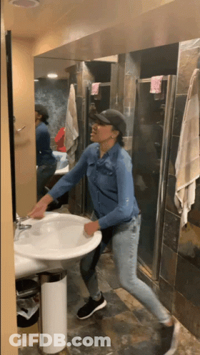 A Woman In A Denim Shirt Is Cleaning A Sink GIF