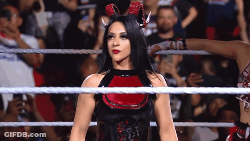 A Woman In A Devil Costume Is In A Wrestling Ring . GIF