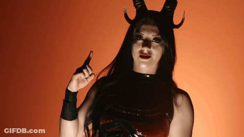 A Woman In A Devil Costume With Horns Pointing Up GIF
