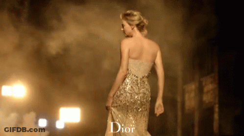 A Woman In A Dior Dress Walking Down A Street GIF