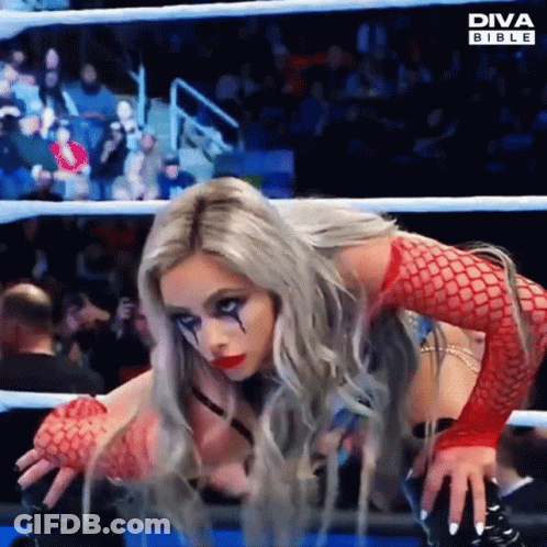 A Woman In A Diva Bible Outfit Is Kneeling Down In A Ring GIF