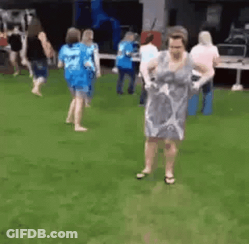 Woman Dancing In Grass With Others GIF