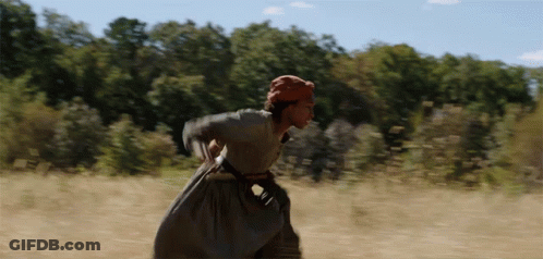A Woman In A Dress Is Running In A Field GIF