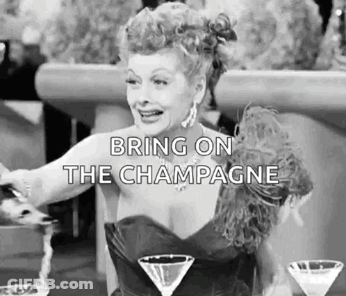 A Woman In A Dress Is Sitting At A Table With Two Martini Glasses And A Glass Of Champagne . GIF