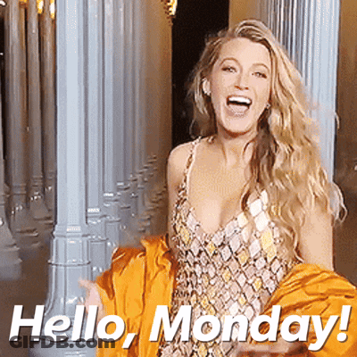 A Woman In A Dress Is Standing In Front Of Columns And Says Hello Monday GIF