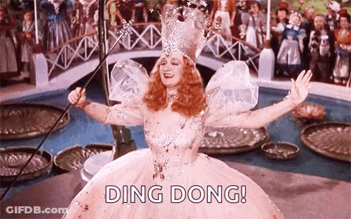 A Woman In A Fairy Costume Is Holding A Wand In Her Hand . GIF