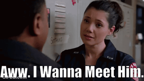 A Woman In A Firefighter Uniform Says " Aww I Wanna Meet Him " To A Man GIF