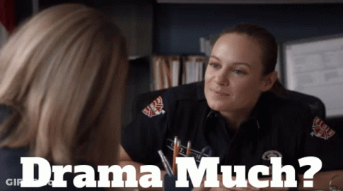 A Woman In A Firefighter Uniform Talks To Another Woman With The Words Drama Much Below Her GIF