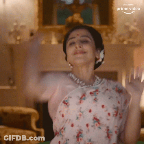 A Woman In A Floral Dress Is Dancing In A Living Room With The Amazon Prime Video Logo Visible GIF