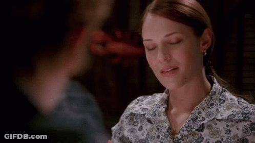 A Woman In A Floral Shirt Is Looking At Another Woman GIF