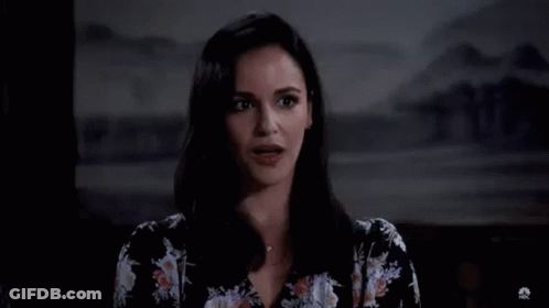 A Woman In A Floral Shirt Is Standing In Front Of A Large H . GIF