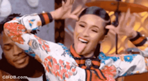 A Woman In A Floral Shirt Is Sticking Her Tongue Out . GIF
