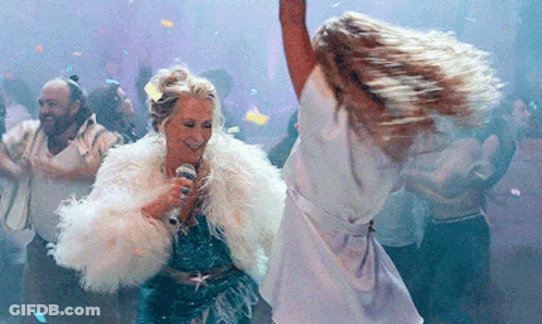 A Woman In A Fur Coat Is Singing Into A Microphone While Dancing GIF