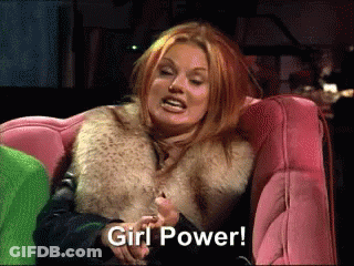 A Woman In A Fur Coat Is Sitting On A Pink Couch And Saying Girl Power GIF