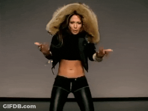 A Woman In A Fur Hooded Jacket Is Dancing On A Stage . GIF