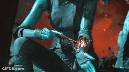 A Woman In A Futuristic Outfit Is Holding A Red Object In Her Hand GIF