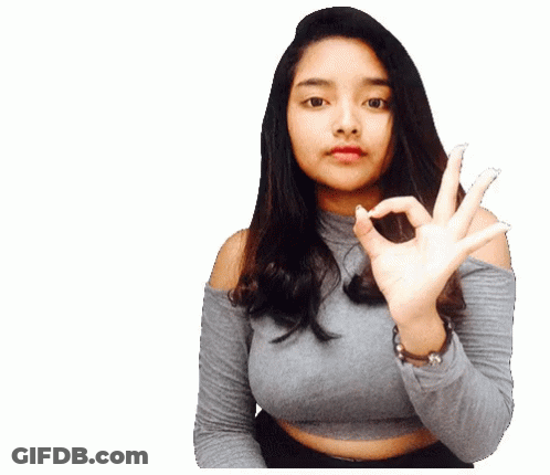 A Woman In A Gray Top Is Making An Ok Sign With Her Hands GIF