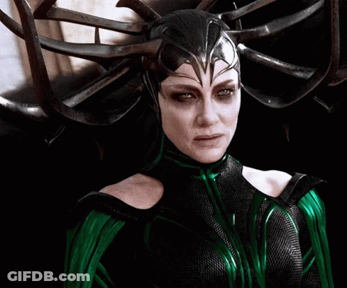 A Woman In A Green And Black Costume With A Helmet On Her Head GIF