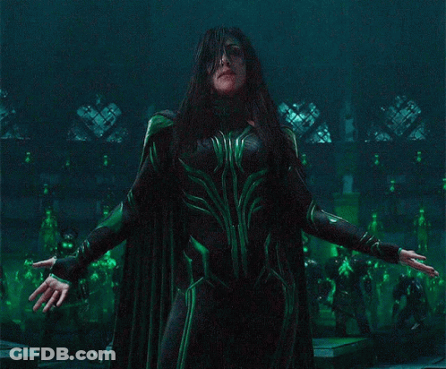 A Woman In A Green Costume Is Standing In A Dark Room GIF