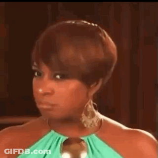 A Woman In A Green Dress And Earrings Is Making A Face . GIF