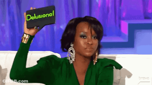 A Woman In A Green Dress Is Holding A Card That Says Delusional GIF