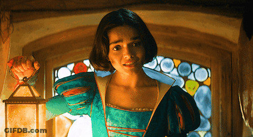 A Woman In A Green Dress Is Holding A Lantern GIF