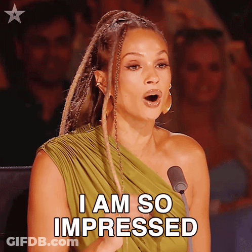 A Woman In A Green Dress Is Speaking Into A Microphone And Says " I Am So Impressed " GIF