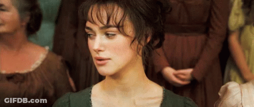 A Woman In A Green Dress Is Standing In Front Of A Crowd Of Women . GIF